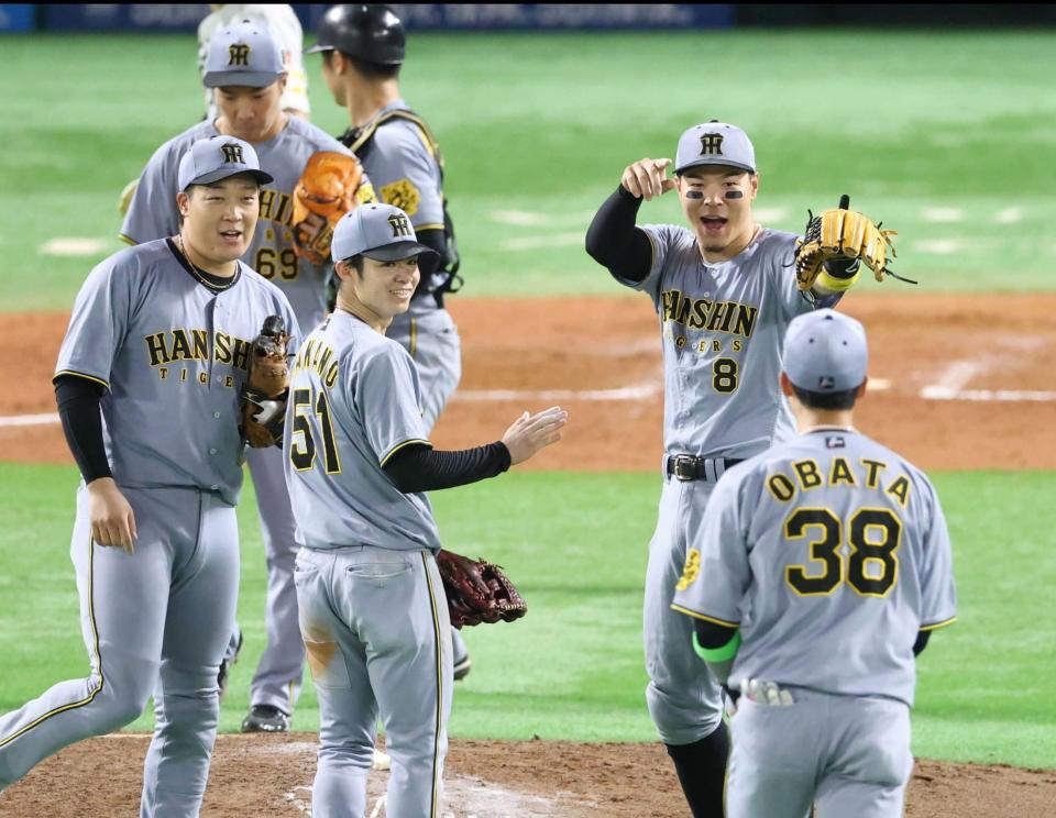 　初戦を勝利し、喜ぶ佐藤輝（右）ら阪神ナイン（撮影・金田祐二）