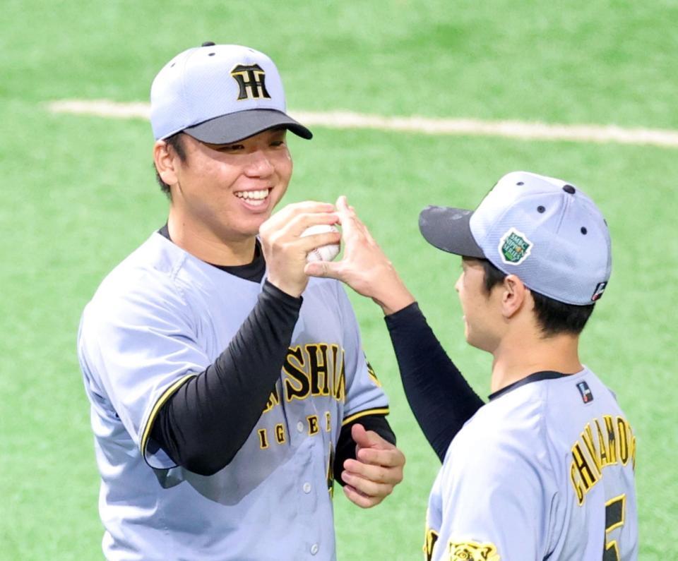 　近本（右）からウイニングボールを手渡され笑顔を見せる村上（撮影・立川洋一郎）