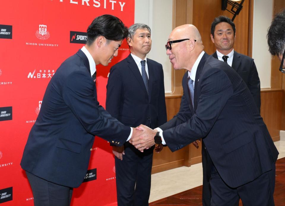 　ドラフト２位指名され、畑山俊二統括スカウト（手前右）からあいさつを受ける日大・谷端将伍（撮影・伊藤笙子）