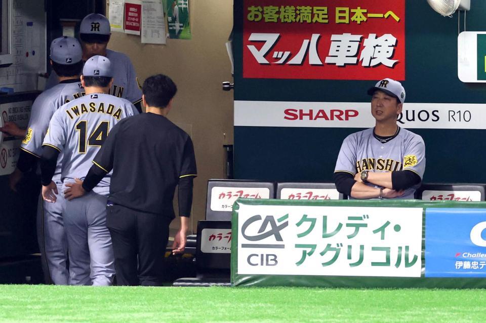 　３回、柳町の打球を受けた岩貞はベンチに戻る（右は藤川監督）＝撮影・山口登