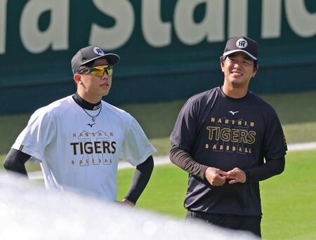 　ウオーミングアップをしながら才木（左）と談笑する高橋（撮影・立川洋一郎）