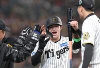 　１回、佐藤輝の先制となる適時二塁打で生還し、ナインとタッチを交わす中野（撮影・北村雅宏）