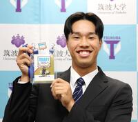 　藤川監督のサイン入りドラフト会議パスを手にするドラフト３位指名の筑波大・岡城快生（撮影・佐々木彰尚）