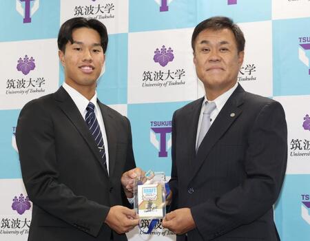 　平塚克洋スカウト（右）から藤川監督のサイン入りドラフト会議パスを受け取るドラフト３位指名の筑波大・岡城快生（撮影・佐々木彰尚）
