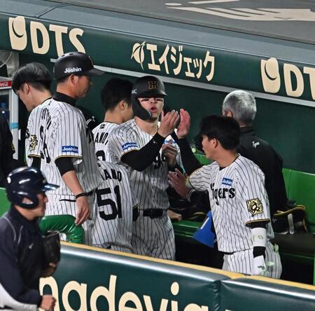 　５回に適時打を放ち、ベンチ内でナインとタッチを交わす佐藤輝（中央）＝撮影・西田忠信