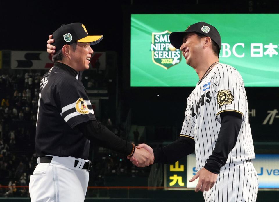 　小久保監督（左）に日本一をお祝いの言葉をかけ、握手を交わす藤川監督（撮影・北村雅宏）