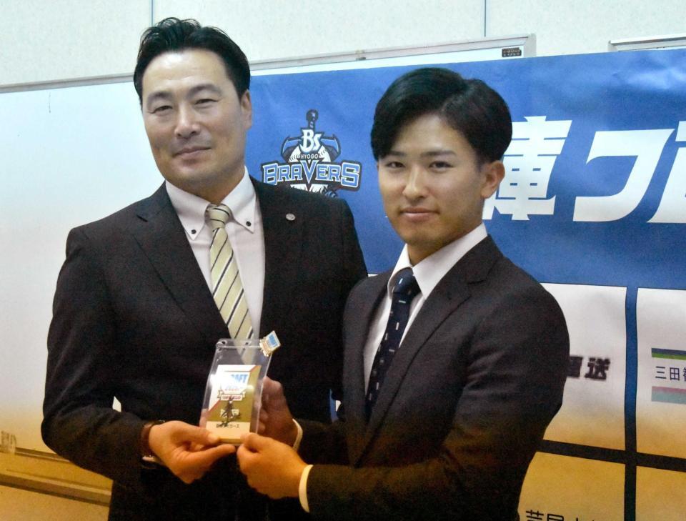 　筒井スカウト（左）から藤川監督のサイン入りカードを受け取る山崎