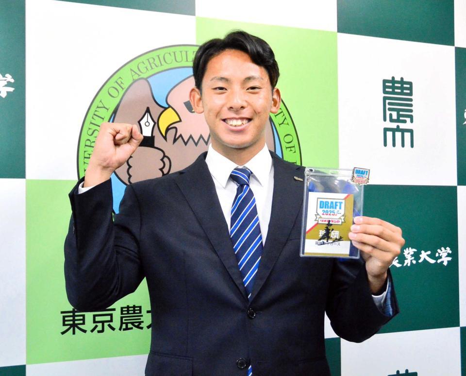 　藤川監督のサイン入りＩＤを手に笑顔を見せる東農大北海道オホーツク・神宮（撮影・間宮涼）