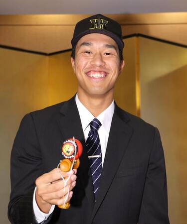 　特技のけん玉を見事に成功させ、笑顔を見せるドラフト３位指名の岡城快生（撮影・吉澤敬太）