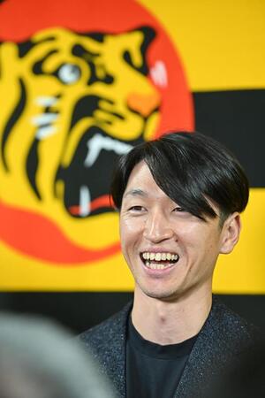 　残留を表明し、笑顔で取材に応じる近本（撮影・西田忠信）