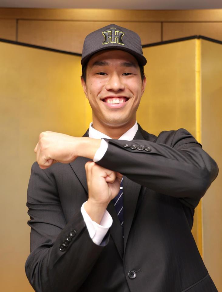 　仮契約交渉を終え、笑顔でＴポーズを決めるドラフト３位指名の岡城快生（撮影・吉澤敬太）