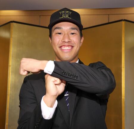 　仮契約交渉を終え、笑顔でＴポーズを決める阪神ドラフト３位指名の岡城（撮影・吉澤敬太）