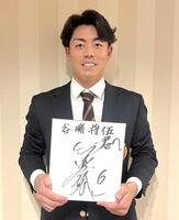 　金本氏からのサインを手に笑顔を見せる谷端