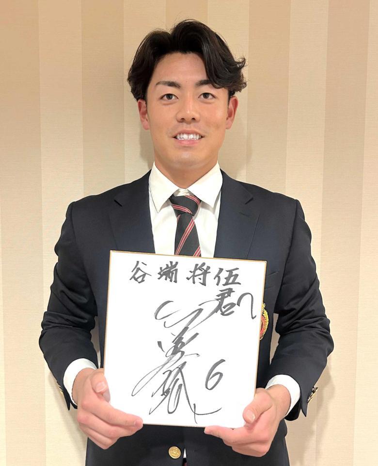 　金本氏からのサインを手に笑顔を見せる谷端
