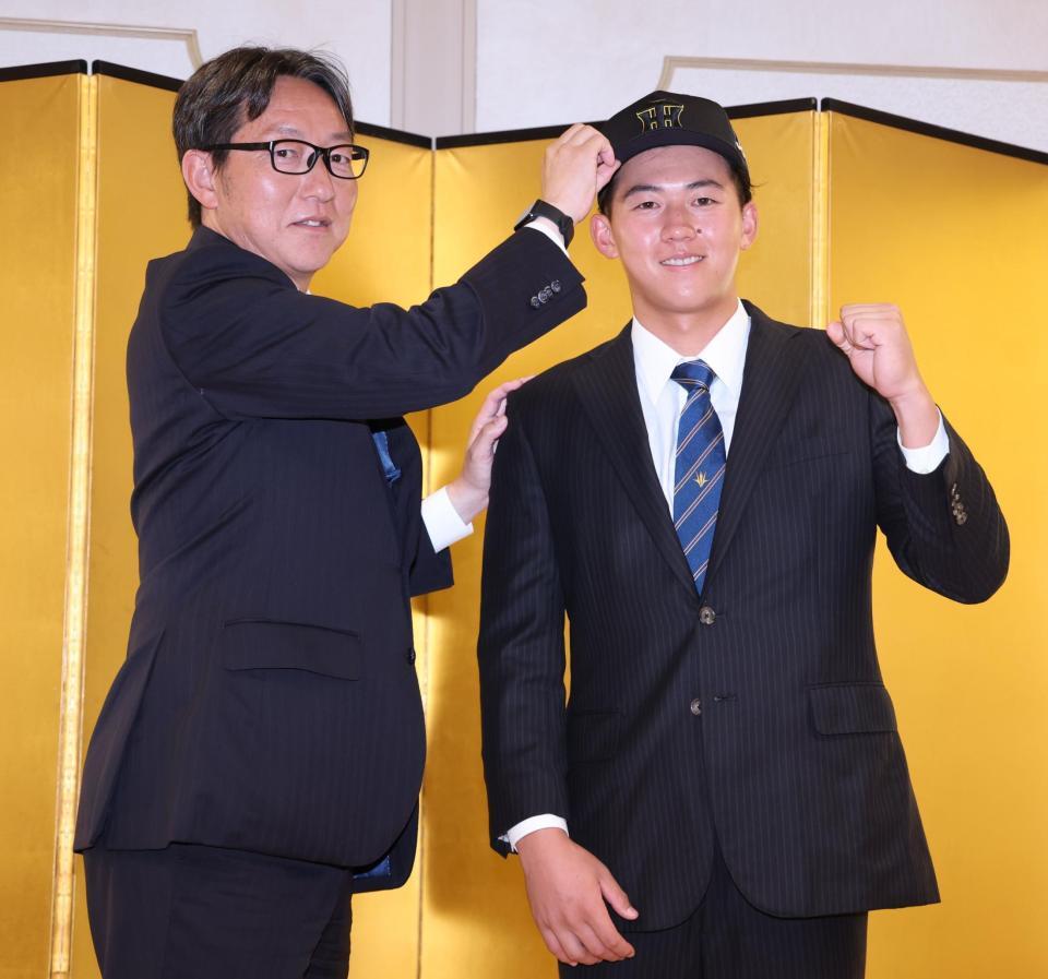 　仮契約交渉を終え吉野スカウトから帽子をかぶらせてもらうドラフト１位・立石（撮影・金田祐二）