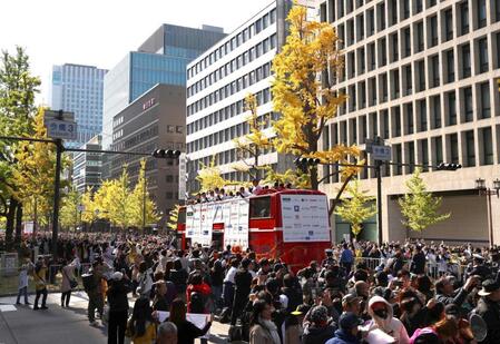 　ファンで埋め尽くされた沿道をゆっくりと進むバス（撮影・北村雅宏）