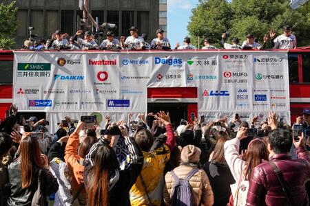 　大阪・御堂筋で行われたセ・リーグ優勝記念パレードで、ファンに手を振る阪神の選手ら