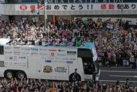 　「祝　優勝おめでとう！！」の横断幕を背にファンに手を振る藤川監督（手前右端）ら（撮影・中田匡峻）