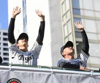 　沿道のビルから見るファンに手を振る小幡（左）と桐敷（撮影・西田忠信）