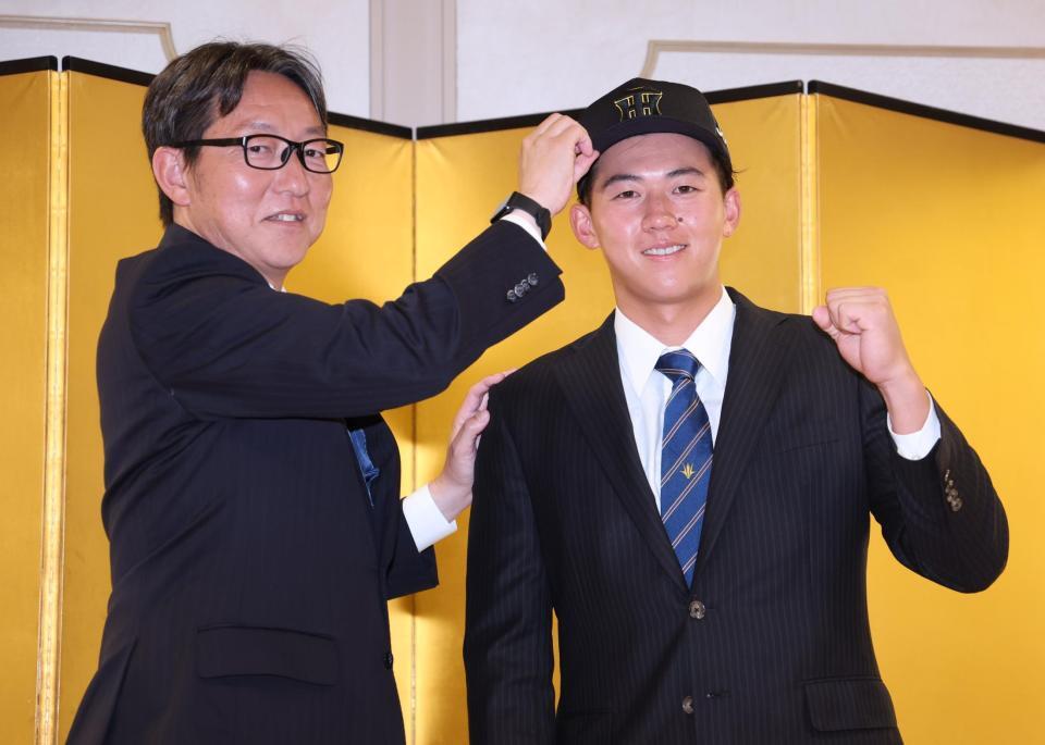 　仮契約交渉を終え吉野スカウトから帽子をかぶらせてもらうドラフト１位・立石（撮影・金田祐二）