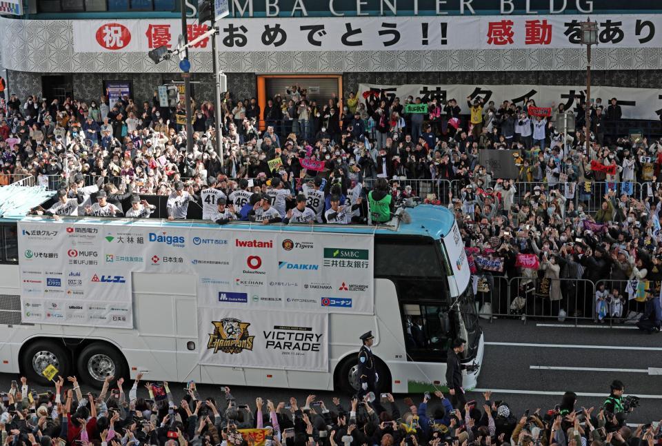 　「祝　優勝おめでとう！！」の横断幕を背にファンに手を振る藤川監督（手前右端）ら（撮影・中田匡峻）