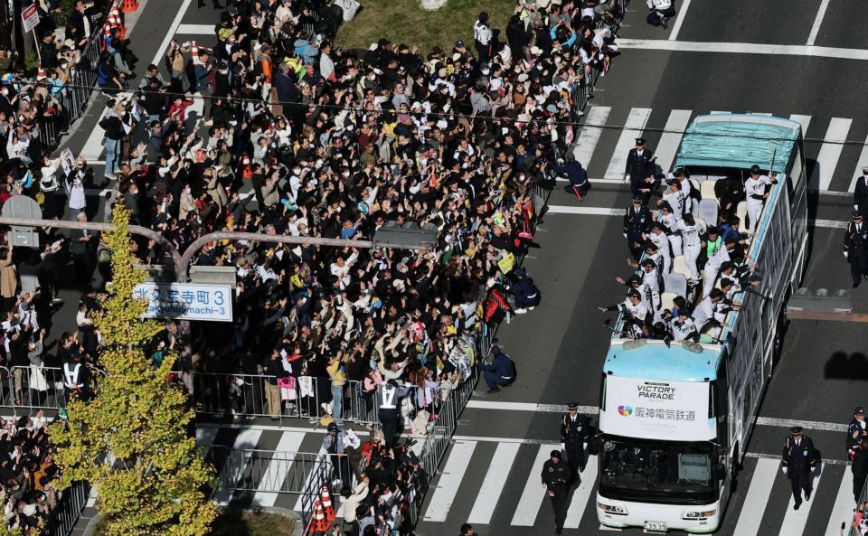 　沿道のファンに手を振る藤川監督らを乗せたパレードカー（撮影・田中太一）