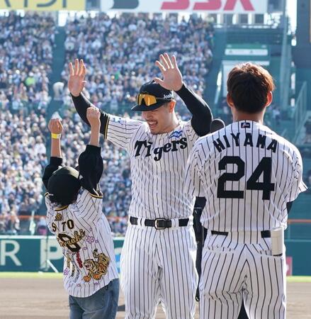　イベントの参加者（左）とハイタッチする佐藤輝（撮影・西田忠信）