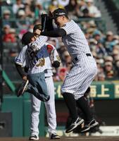 　ファン感謝デーで子どもとタッチを交わす佐藤輝（右）