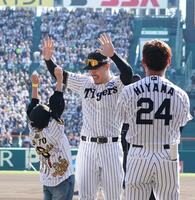 　イベントの参加者（左）とハイタッチする佐藤輝（撮影・西田忠信）