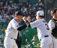 　現役選手チーム相手に最後を締め、掛布雅之ＯＢ会長（右）に迎えられる藤川監督（撮影・西田忠信）