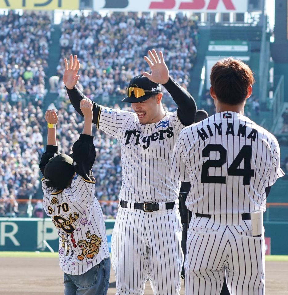 　イベントの参加者（左）とハイタッチする佐藤輝（撮影・西田忠信）