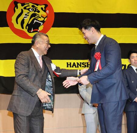 　掛布雅之ＯＢ会会長（左）から表彰を受け、笑顔を見せる佐藤輝（撮影・田中太一）