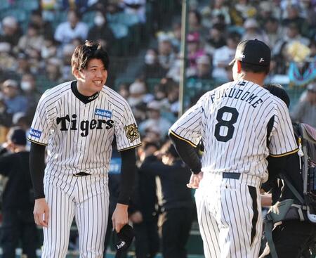 　福留孝介氏（右）から声をかけられる才木（撮影・西田忠信）