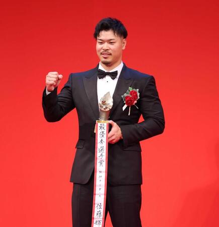 　セ・リーグＭＶＰを受賞し、笑顔でガッツポーズする佐藤輝（撮影・西岡正）