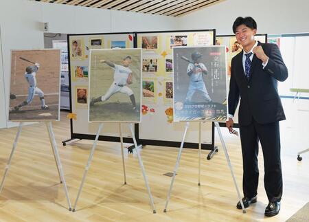 　展望回廊に飾られた、自身の小中高時代の写真パネルと並んで笑顔を見せる阪神ドラフト１位・立石（創価大）＝撮影・立川洋一郎