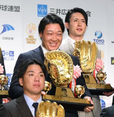 　記念撮影で手にしたゴールデン・グラブの傾きを指摘され苦笑いの大山（撮影・堀内翔）