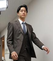 　契約更改を終え、会見の席へと向かう小幡（撮影・立川洋一郎）