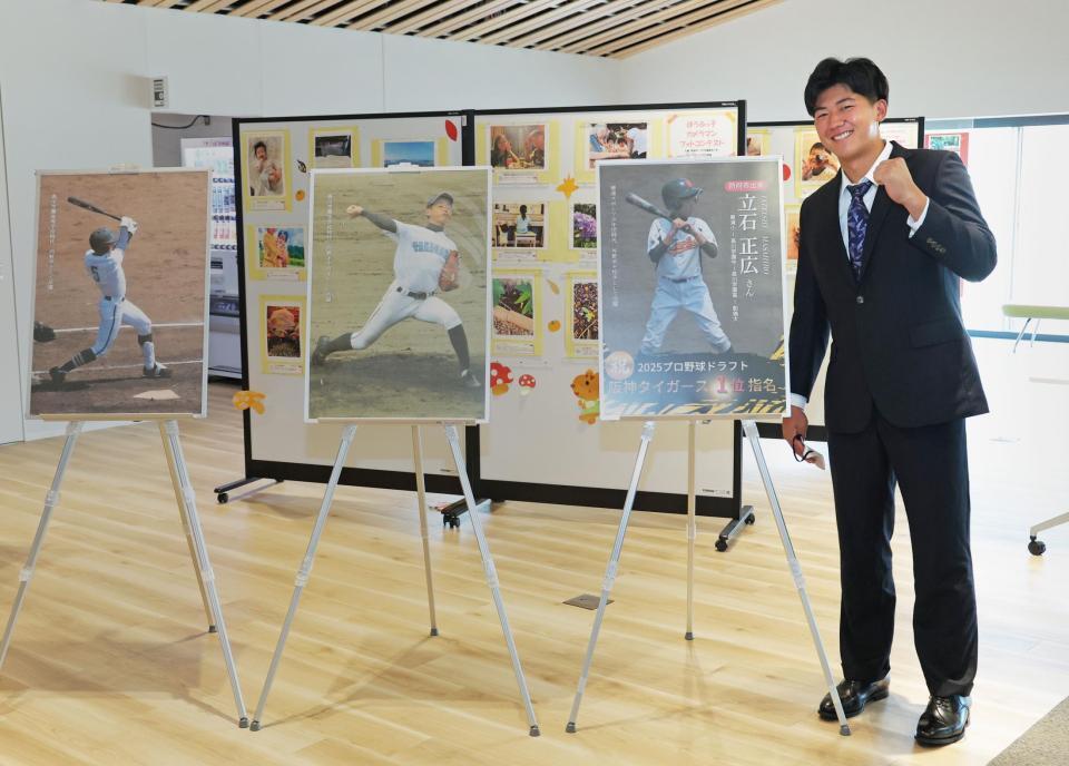 　展望回廊に飾られた、自身の小中高時代の写真パネルと並んで笑顔を見せる阪神ドラフト１位・立石（創価大）＝撮影・立川洋一郎