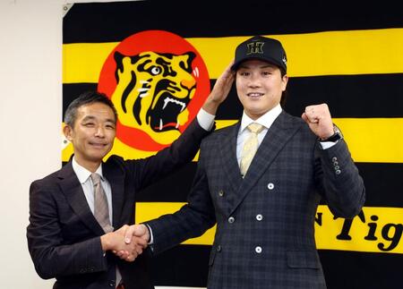 　伏見（右）は竹内孝行副本部長から帽子を被せてもらいポーズを決める（撮影・山口登）