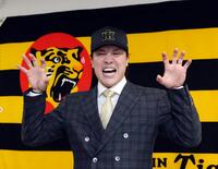 　入団会見で虎ポーズを決める伏見（撮影・山口登）