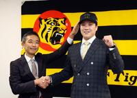 　伏見（右）は竹内孝行副本部長から帽子を被せてもらいポーズを決める（撮影・山口登）