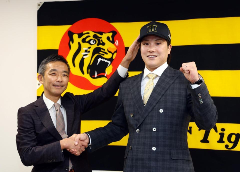 　伏見（右）は竹内孝行副本部長から帽子を被せてもらいポーズを決める（撮影・山口登）