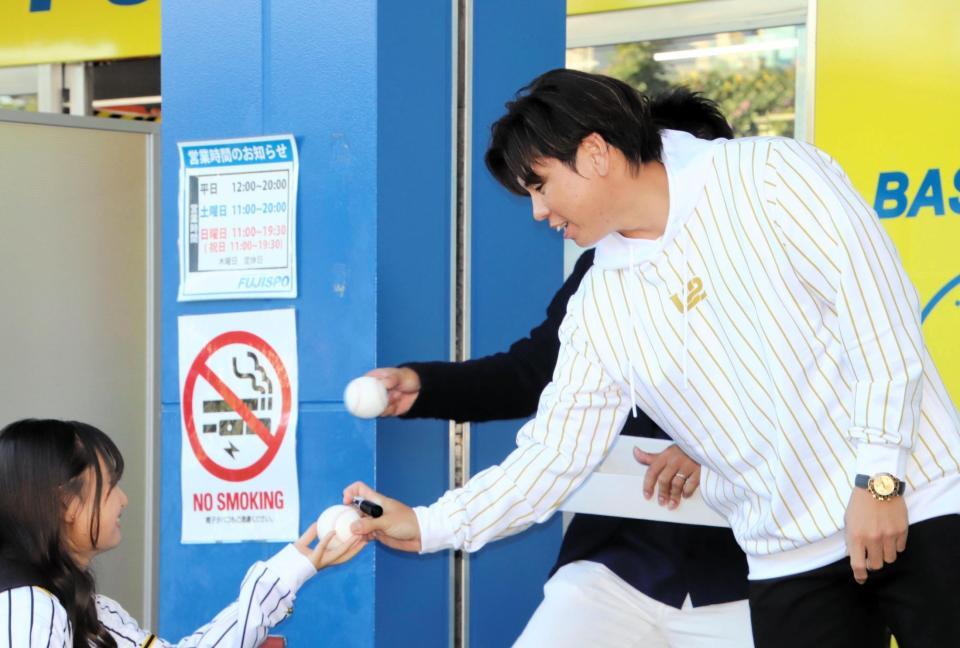 　サインボールをファンに手渡す梅野