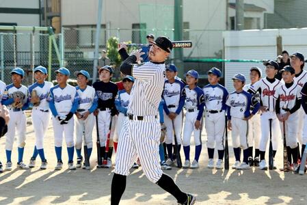 　少年野球チームの前で打撃のお手本を見せる佐藤輝（撮影・田中太一）