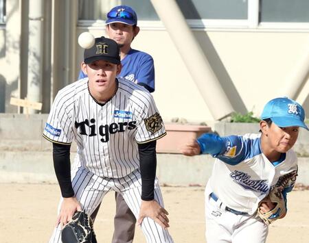 　野球チームの投球練習を見る富田（撮影・田中太一）