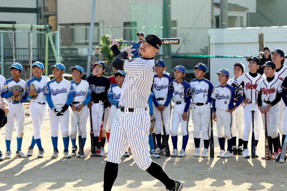 　少年野球チームの前で打撃のお手本を見せる佐藤輝（撮影・田中太一）