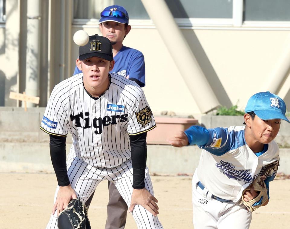 　野球チームの投球練習を見る富田（撮影・田中太一）