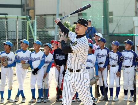 　子供の前でスイングする佐藤輝（撮影・田中太一）