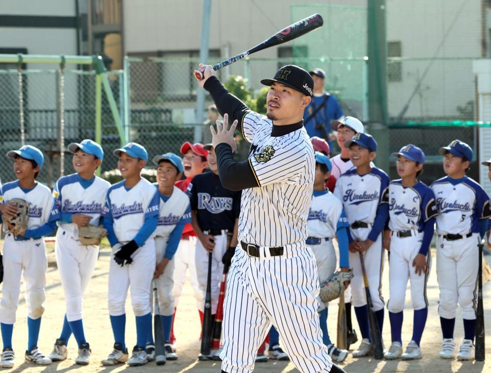 　子供の前でスイングする佐藤輝（撮影・田中太一）