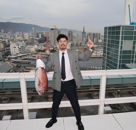 　神戸の街から日本一へ！！ 鯛を手にポーズを決める佐藤輝（撮影・田中太一）